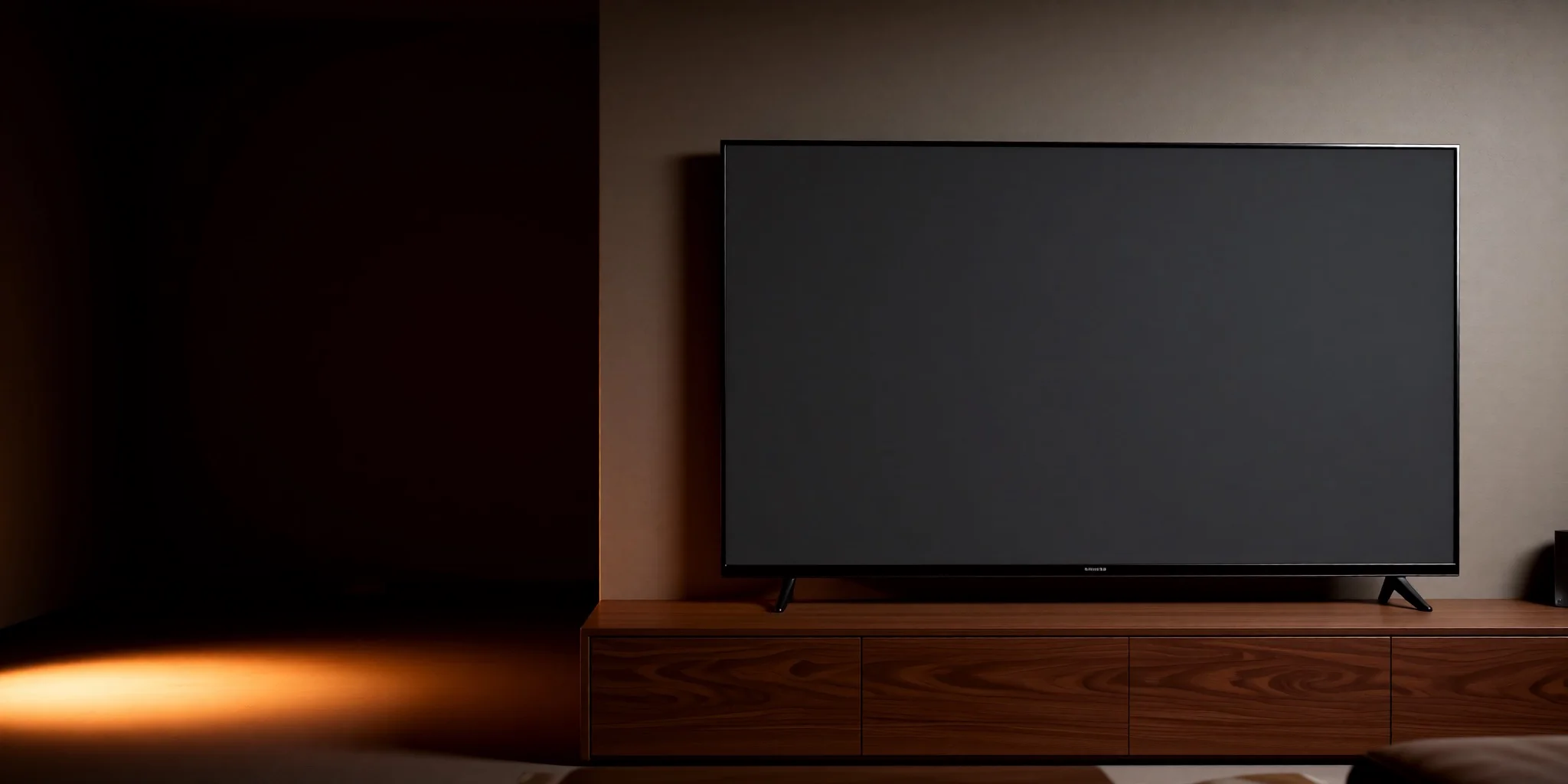 A large television on a walnut console in a dim living room, lit by a warm lamp off to the left.